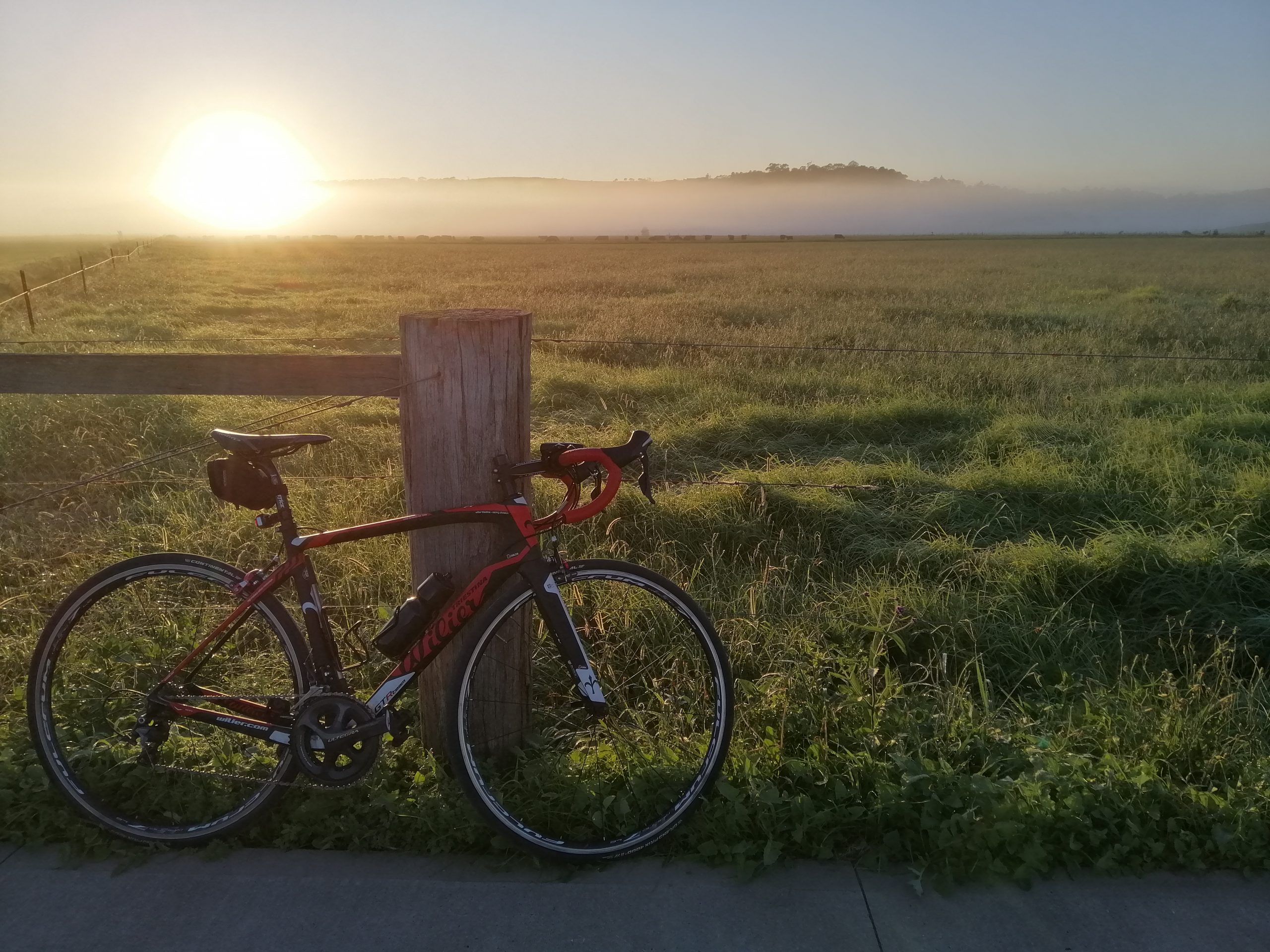 bike on path in front of field at sunrise